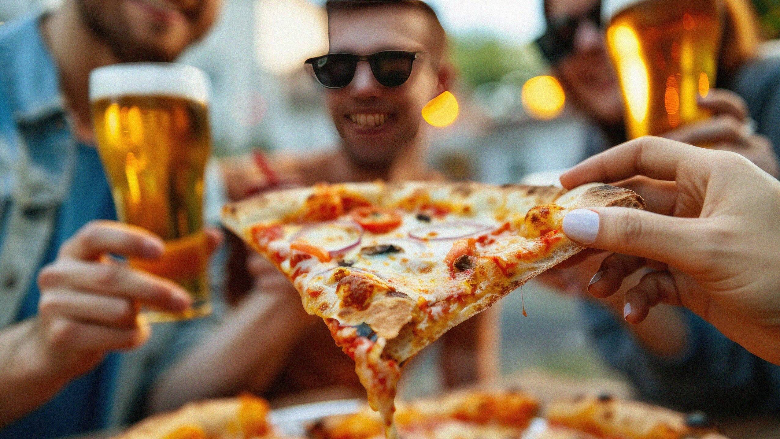 Guys enjoying outdoor pizza
